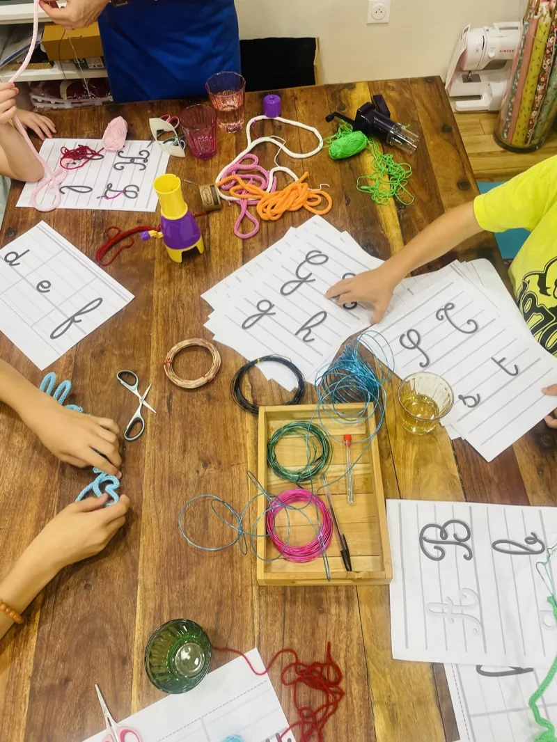 Un atelier créatif en cours autour de la grande table de Moha